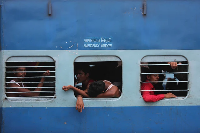 La borers sit inside a train as they prepare to leave the region, at a railway station in Jammu.