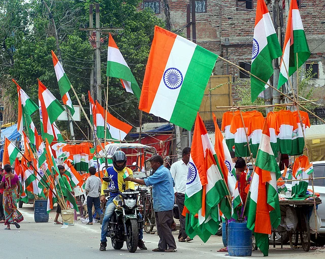 Vendors sell tricolours at roadside shops ahead of the Independence Day, in Noida. 