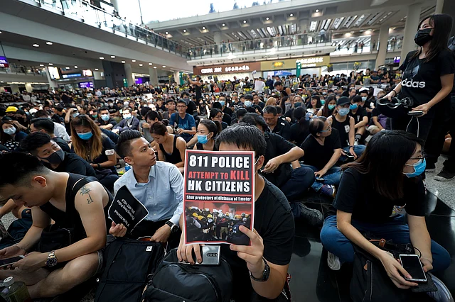 A man holds a placard as thousands of protesters take part in a sit-in rally at the arrival hall of the Hong Kong International Airport. 