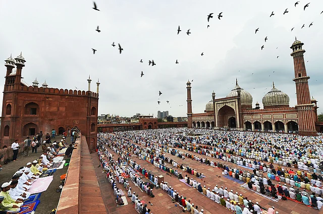 Pigeons fly past as Muslims offer prayers at Jama Masjid on the occasion of Eid al-Adha, in New Delhi, Monday.