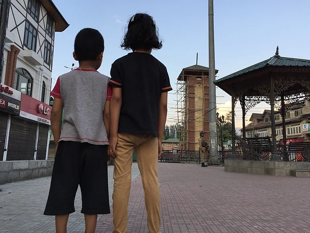 Two kids gazing at the empty streets of Lal Chowk in Srinagar. 