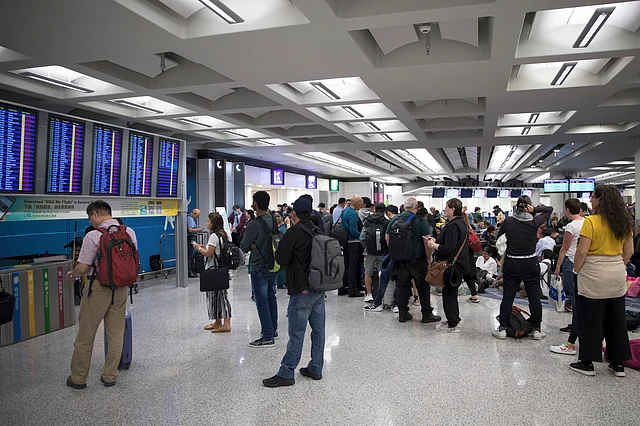 Travellers are stranded at the transit hall after authorities canceled all flights as thousands of protesters take part in a sit-in rally.