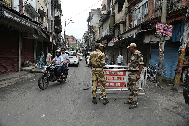 Security officers stand guard near a barricade in Jammu.