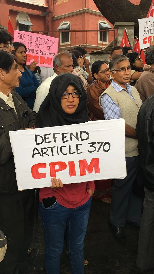 A young protester holds a banner in support of Article 370 in Jammu and Kashmir.