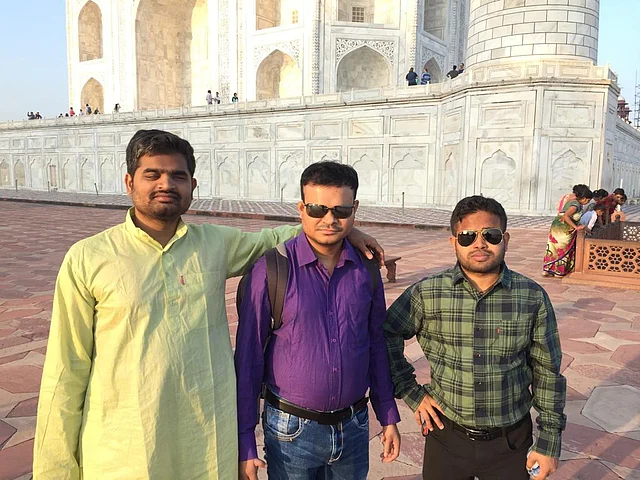 Basanta Behera, Ananta Kumar Nayak, and Amit Kumar Mohanty pose in front of the Taj Mahal.