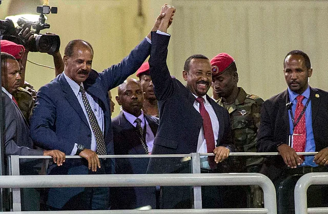 Eritrean President Isaias Afwerki, second left, and Ethiopia’s Prime Minister Abiy Ahmed, center, hold hands as they wave at the crowds in Addis Ababa, Ethiopia. Once official rivals, the leaders of Ethiopia and Eritrea have embraced warmly to the roar of a crowd of thousands at a concert celebrating the end of a long state of war.