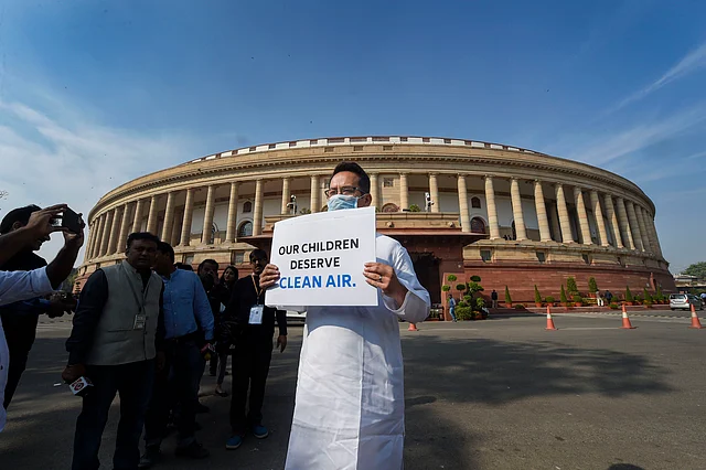Congress MP Gaurav Gogoi displays a placard to protest against government inaction on pollution, on the first day of the Winter Session of Parliament on Monday.