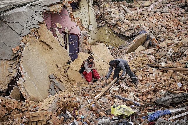 Occupants gather near the debris of their demolished house after an anti-encroachment drive outside the Jammu Airport, in Jammu on Thursday.
