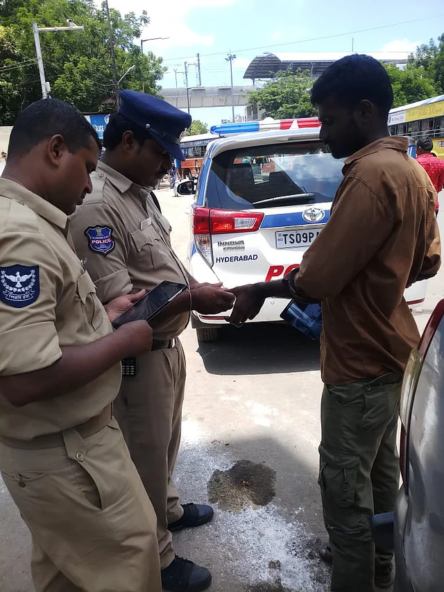 Police personnel taking biometrics of people to compare with the database of known criminals.