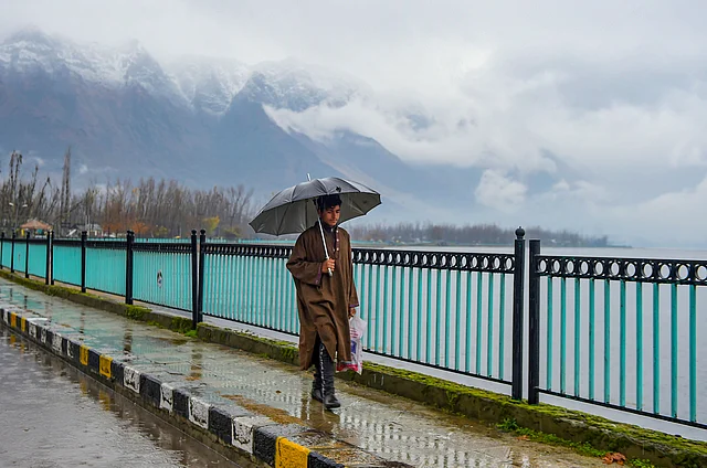A pedestrian walks along the bank of Dal Lake, in Srinagar on Wednesday.