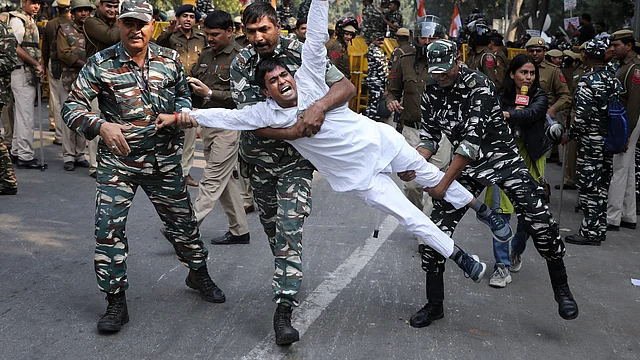 Paramilitary soldiers detain a Congress party supporter during a protest on Wednesday against the withdrawal of SPG cover to Sonia Gandhi, Rahul Gandhi and Priyanka Vadra.