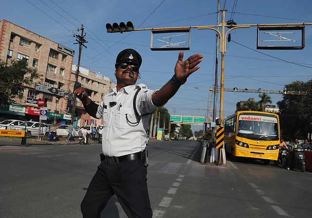 Ranjeet Singh, traffic policeman, directs commuters at a busy intersection in Indore on Monday.