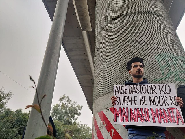 A student holding a placard etched with Habib Jalib’s famous poem.