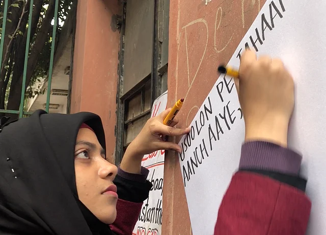 Khansa Fahad, a second-year student at Jamia, makes placards for protesters.