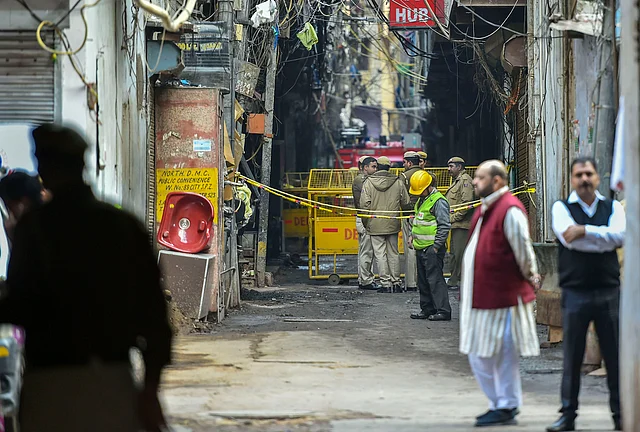 Onlookers stand near a factory at Rani Jhansi Road where a major fire broke out, in New Delhi on 8 December.