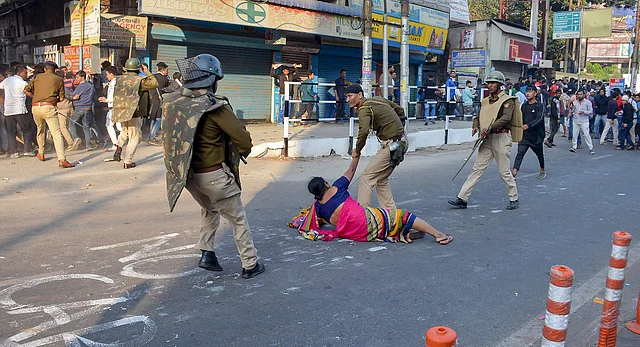 A woman is assisted after a fall as police personnel clash with agitators in Guwahati on Thursday.