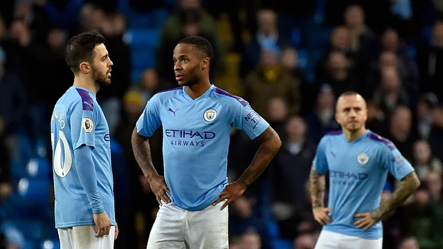 Manchester City’s Bernardo Silva, left, speaks with Manchester City’s Raheem Sterling, center, during the English Premier League soccer match between Manchester City and Manchester United.