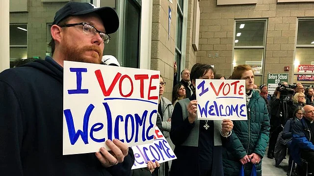 Residents in support of continued refugee resettlement hold signs at a meeting in Bismarck, NDA federal judge agreed Wednesday, 15 January 2020.