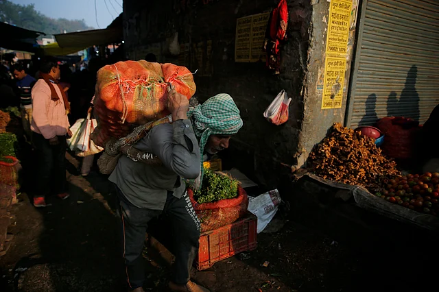 People buy vegetables early morning at a wholesale market in Lucknow on Monday, 27 January. 