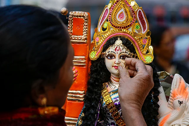A Hindu devotee puts an ornament on a clay image of Saraswati, the Hindu goddess of wisdom, ahead of Basant Panchami in Kolkata on Tuesday, 28 January. 