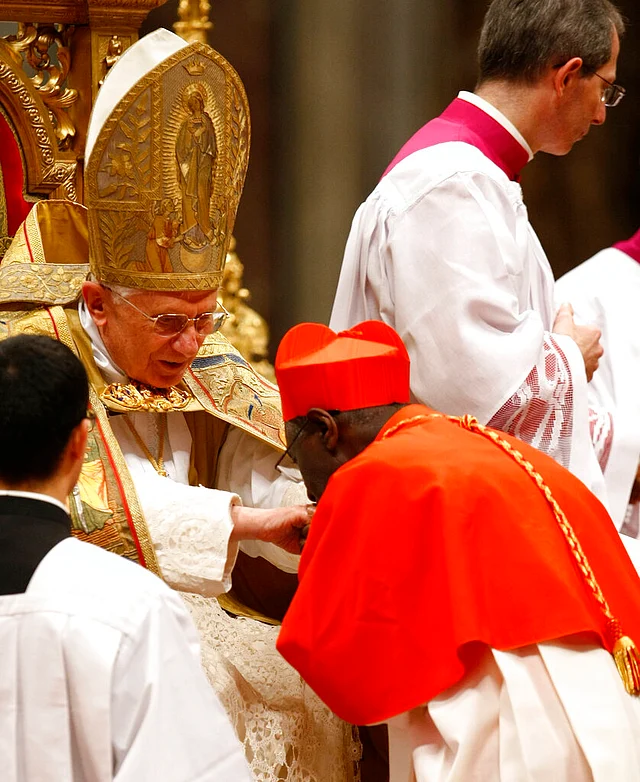Newly-elevated Guinean Cardinal Robert Sarah, right, kisses then Pope Benedict XVI’s hand after receiving the red three-cornered biretta hat during a consistory inside St Peter’s Basilica, at the Vatican on 20 November 2010.