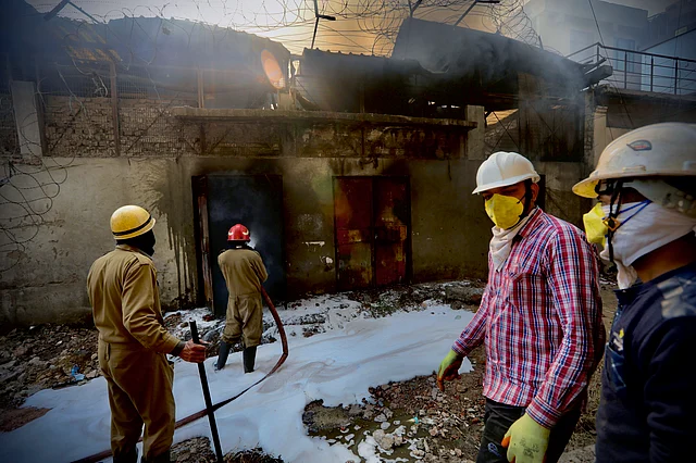 Firemen try to douse fire after a factory manufacturing batteries caught fire and collapsed in Peera Garhi area in western New Delhi, India, Thursday, 2 Jan 2020.