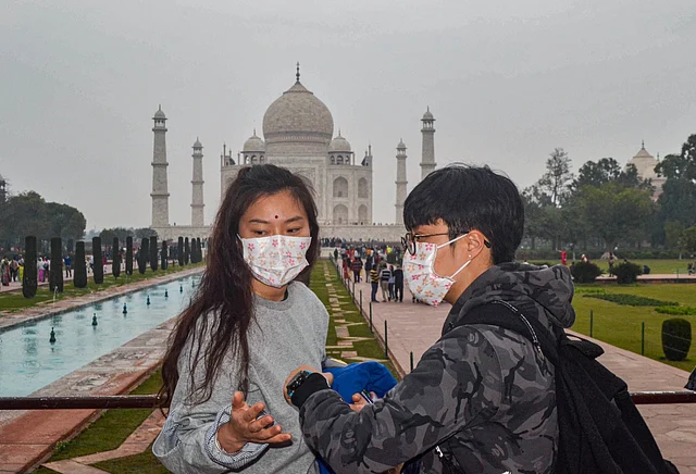 Tourists, wearing protective face masks, visit Taj Mahal, in Agra on Tuesday, 28 January. The Centre on Monday decided to take steps for possible evacuation of over 250 Indians from the Chinese city of Wuhan, the epicentre of the coronavirus outbreak, and announced a raft of precautionary measures to deal with the suspected cases. 