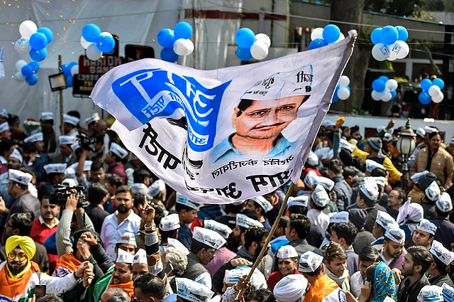 Aam Aadmi Party workers celebrate ahead of the final results, as early trends show the party’s victory in the Delhi Assembly polls, at party headquarters in New Delhi.