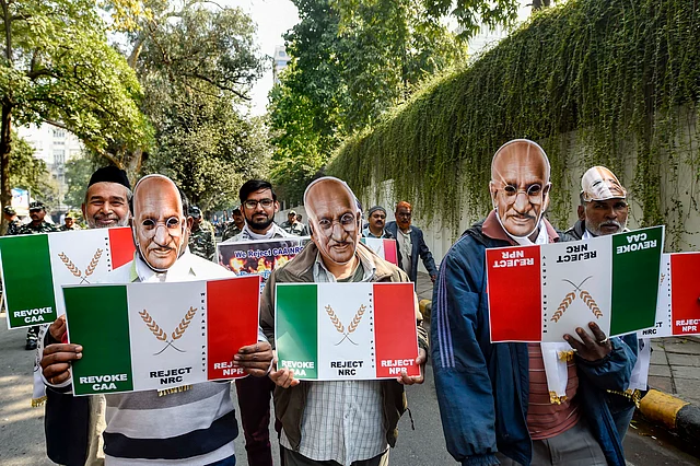 Protesters, wearing Mahatma Gandhi masks, hold placards during a protest march from Mandi House to Jantar Mantar against CAA, NRC, NPR on Monday.