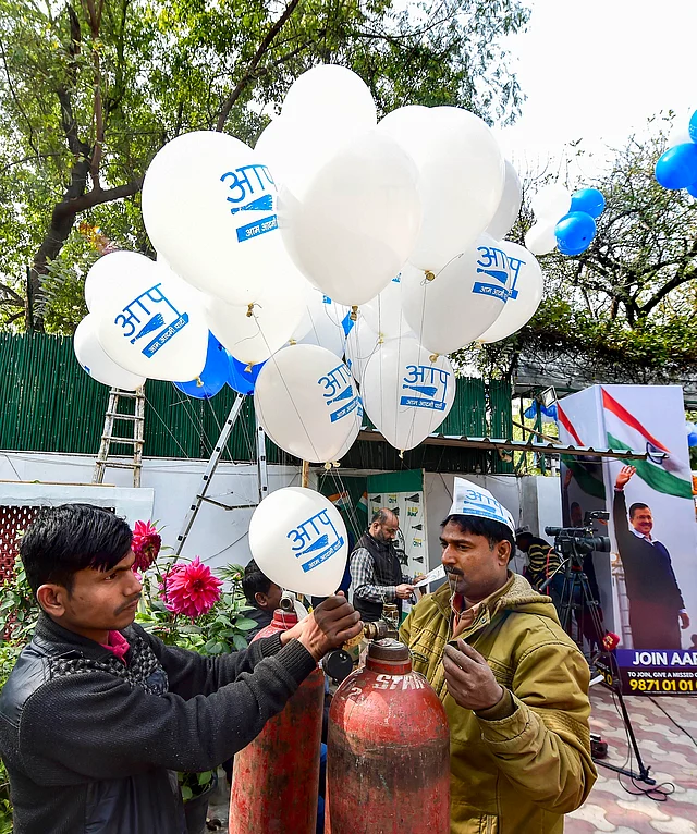 Aam Aadmi Party workers celebrate ahead of the final results, as early trends show the party’s victory in the Delhi Assembly polls, at party headquarters in New Delhi.