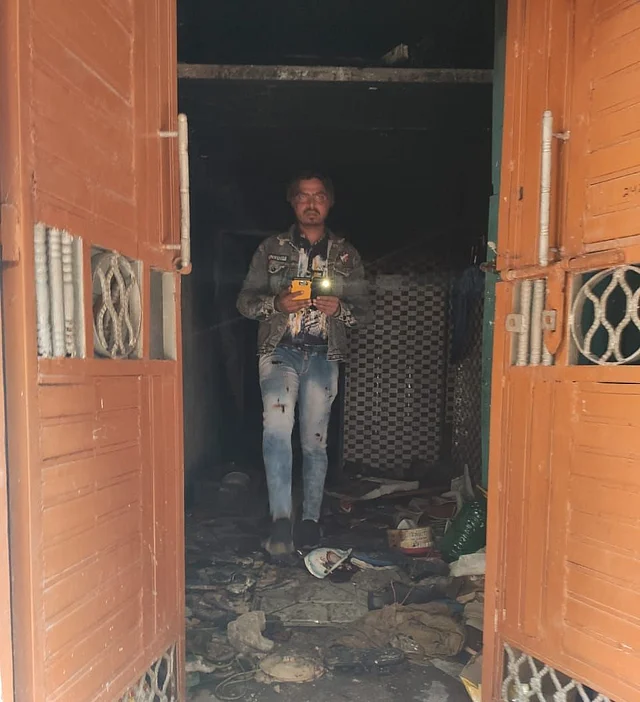 A resident of Ashok Nagar looks for his belongings inside his vandalised house in Ashok Nagar on 26 February