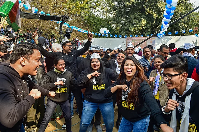 Aam Aadmi Party workers celebrate ahead of the final results, as early trends show the party’s victory in the Delhi Assembly polls, at party headquarters in New Delhi.