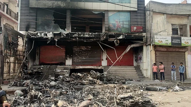 Residents survey the damage to their neighbourhood in Chand Bagh