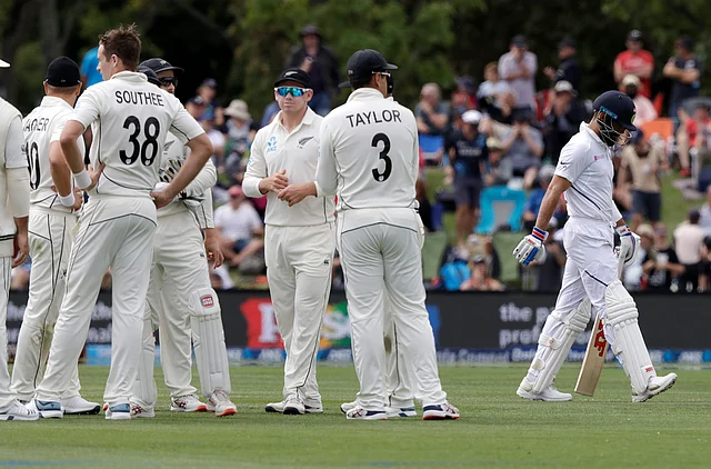 India’s Virat Kohli walks from the field after he was dismissed by New Zealand’s Tim Southee, left, for three runs during play on day one of the second cricket test between New Zealand and India at Hagley Oval in Christchurch.