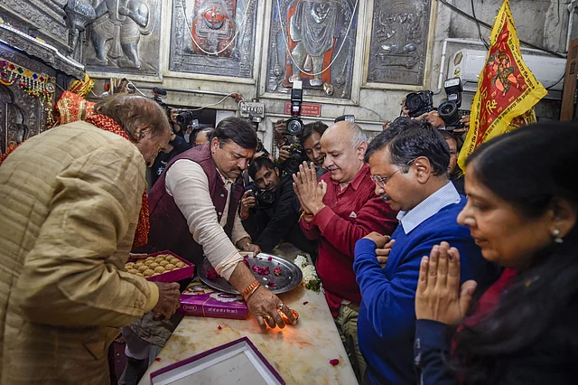 Delhi CM and AAP convenor Arvind Kejriwal (C), accompanied by wife Sunita, Dy CM Manish Sisodia and other party leaders, offers prayers at the Hanuman Mandir in Connaught Place on Tuesday, 11 February 2020.