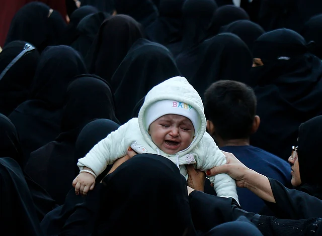 A woman holds her baby among other Burqa clad women at an Anti-CAA, Anti-NRC rally in Mumbai.