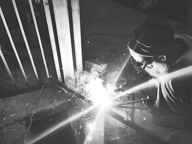 An old Muslim man welding iron rods for new gates in Jafrabad.
