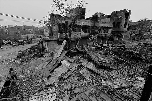 Shiv Vihar crossing strewn with asbestos sheets, burnt cars and broken furnitures.