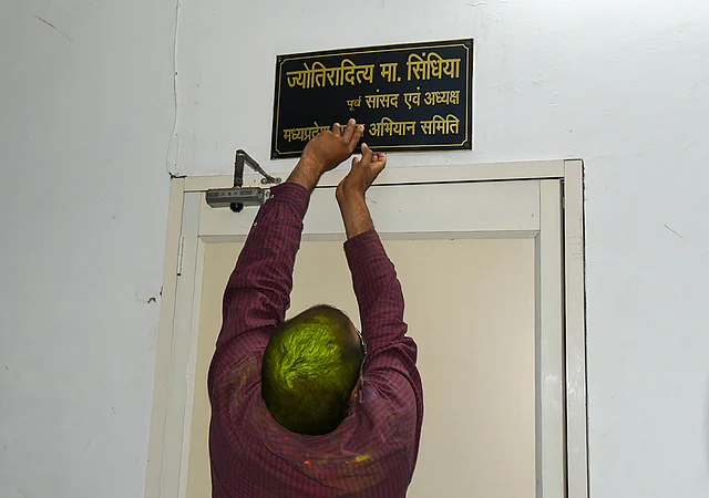 Congress worker removes name plate of Jyotiraditya Scindia from PCC office, in Bhopal, Tuesday, 10 March 2020.