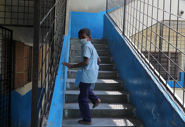 An Indian student wears a mask and climbs a flight of stairs at a government school in Hyderabad, India, Wednesday, 4 March 2020.