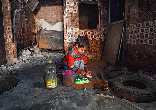 Riot victim Khushi plays with toys in her burnt house, damaged in recent clashes over the amended citizenship law, in Khajuri Khas Extension of Northeast Delhi,Thursday, 12 March 2020.