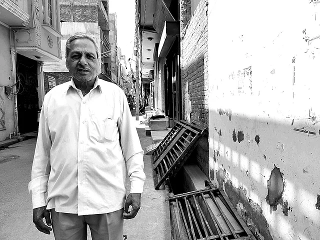 Anant Prakash Gupta stands beside iron gates that will be erected at the entrance of his lane in Brijpuri.