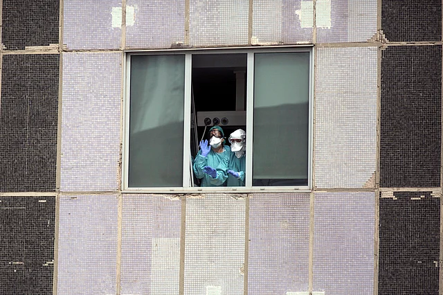 Medical workers wearing masks gesture from hospital La Paz in Madrid, Spain.