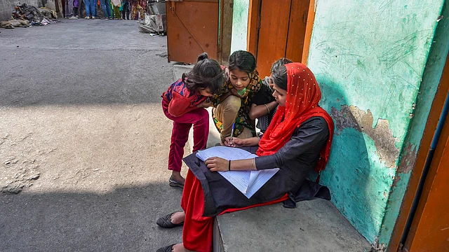 A volunteer makes a list of study material required by neighbourhood children, after recent violence over the amended citizenship law, outside her house in Khajuri Khas Extension of Northeast Delhi, Thursday, 12 March 2020.