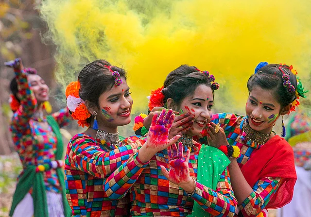 Women smear colours at each other during Holi celebrations, in Nadia district, Tuesday, 3 March, 2020.