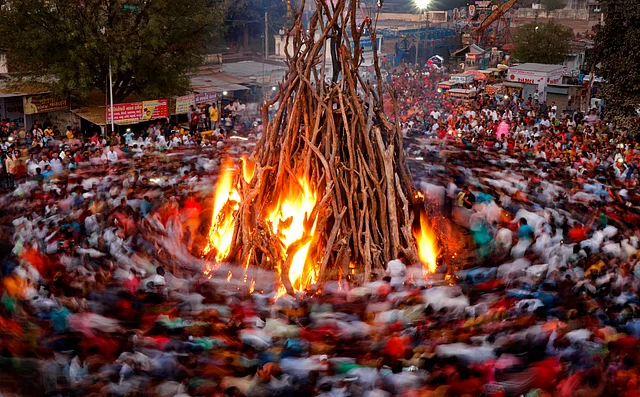 Hindu devotees perform rituals during Holika Dahan on the eve of Holi festival in Gandhinagar, Monday, 9 March 2020.
