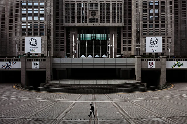 In this 25 February 2020 file photo, a man walks in front of the Tokyo Metropolitan Government building adorned with large banners promoting the Tokyo 2020 Olympics and Paralympics in Tokyo. 