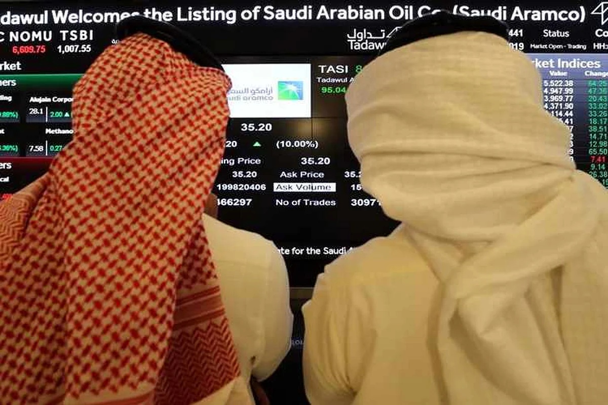Investors monitor a screen displaying stock information at the Saudi Stock Exchange (Tadawul) on the Riyadh's stock market, in Riyadh, Saudi Arabia