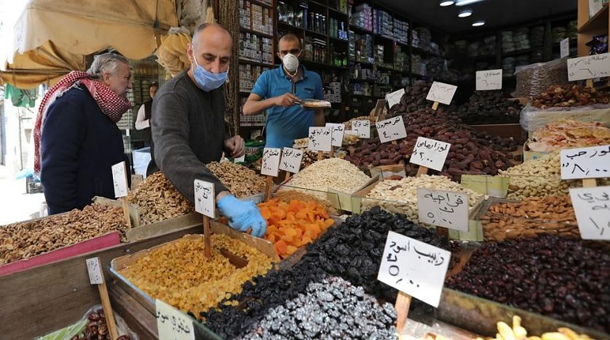Vendors wearing protective face masks serve customers at a shop, ahead of the holy month of Ramadan, in Amman, Jordan on April 21, 2020. (Reuters)