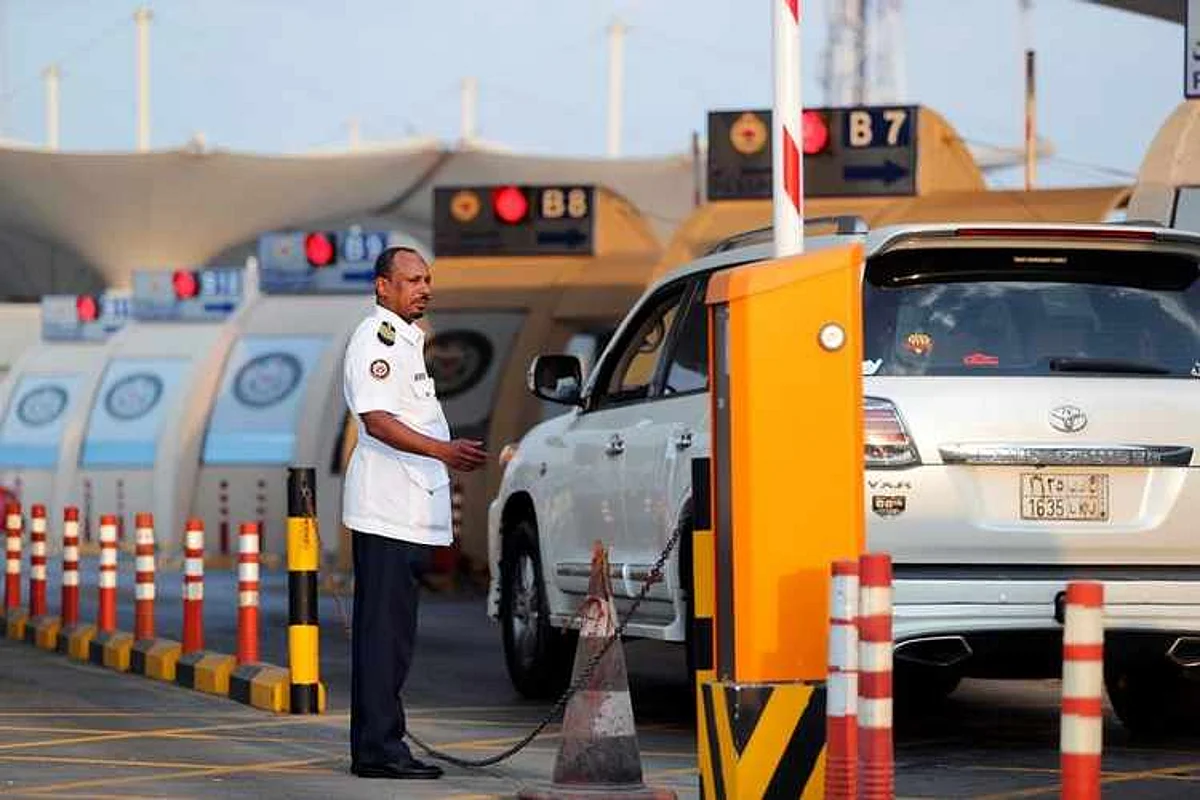 An Immigration officer assists cars arriving during rush hour at the Bahrain Immigration check point at King Fahd Causeway, a bridge connecting Saudi Arabia and Bahrain, at Bahrain Saudi border